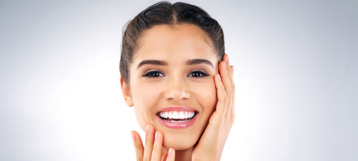 Mujer joven sonriendo con piel luminosa tras aplicar tónico facial