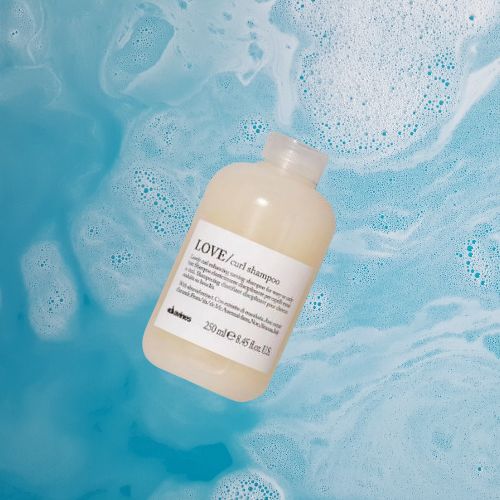 love curl shampoo sobre fondo azul con espuma