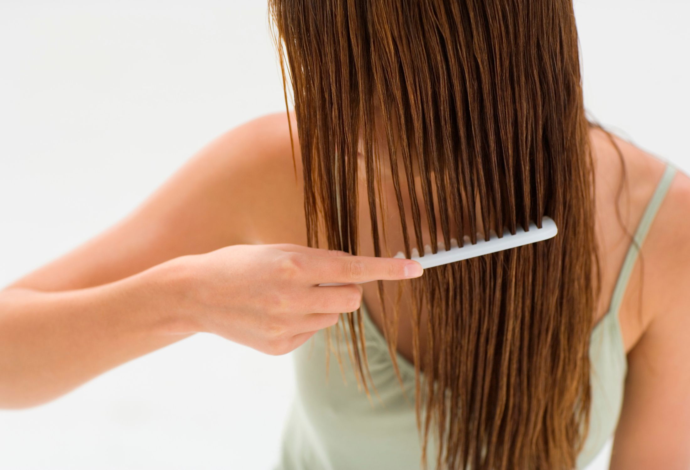 Mujer pein&aacute;ndose el pelo con un cepillo de cerdas anchas