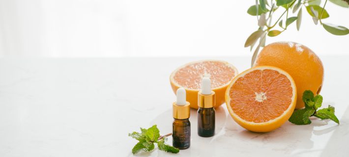 aceites con pipeta sobre una mesa junto con naranjas