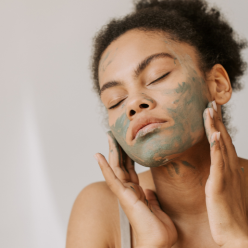 mujer aplic&aacute;ndose una mascarilla de arcilla verde en la cara
