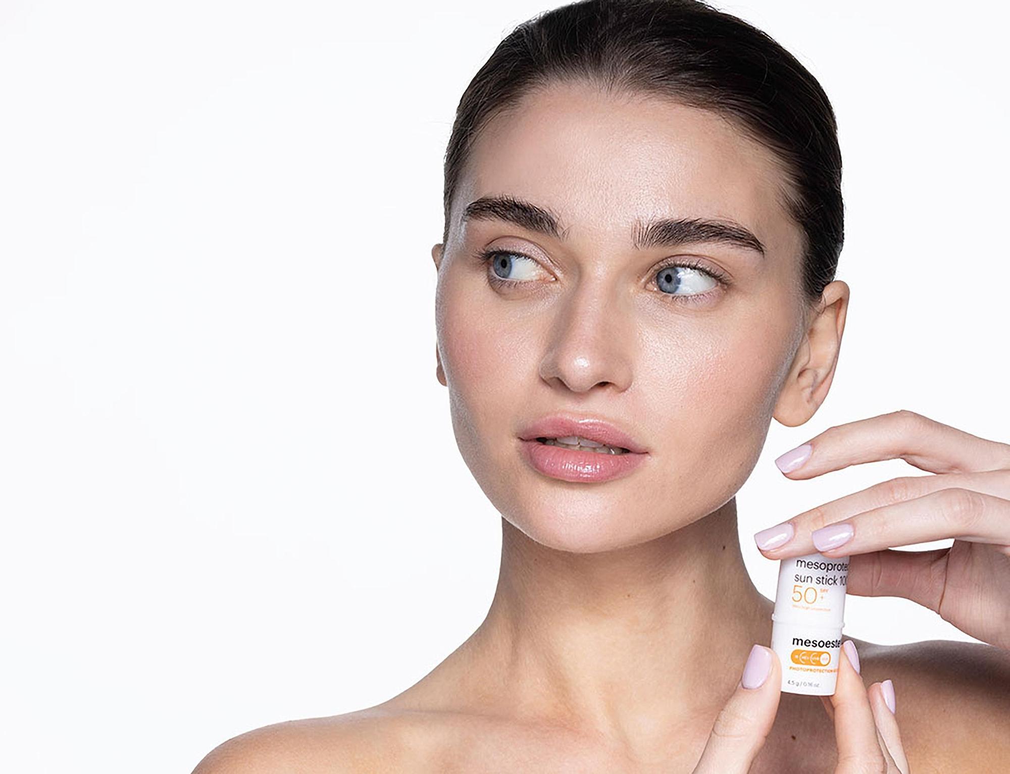 Mujer sosteniendo protector solar facial mesoprotech SPF50 de Mesoestetic en stick